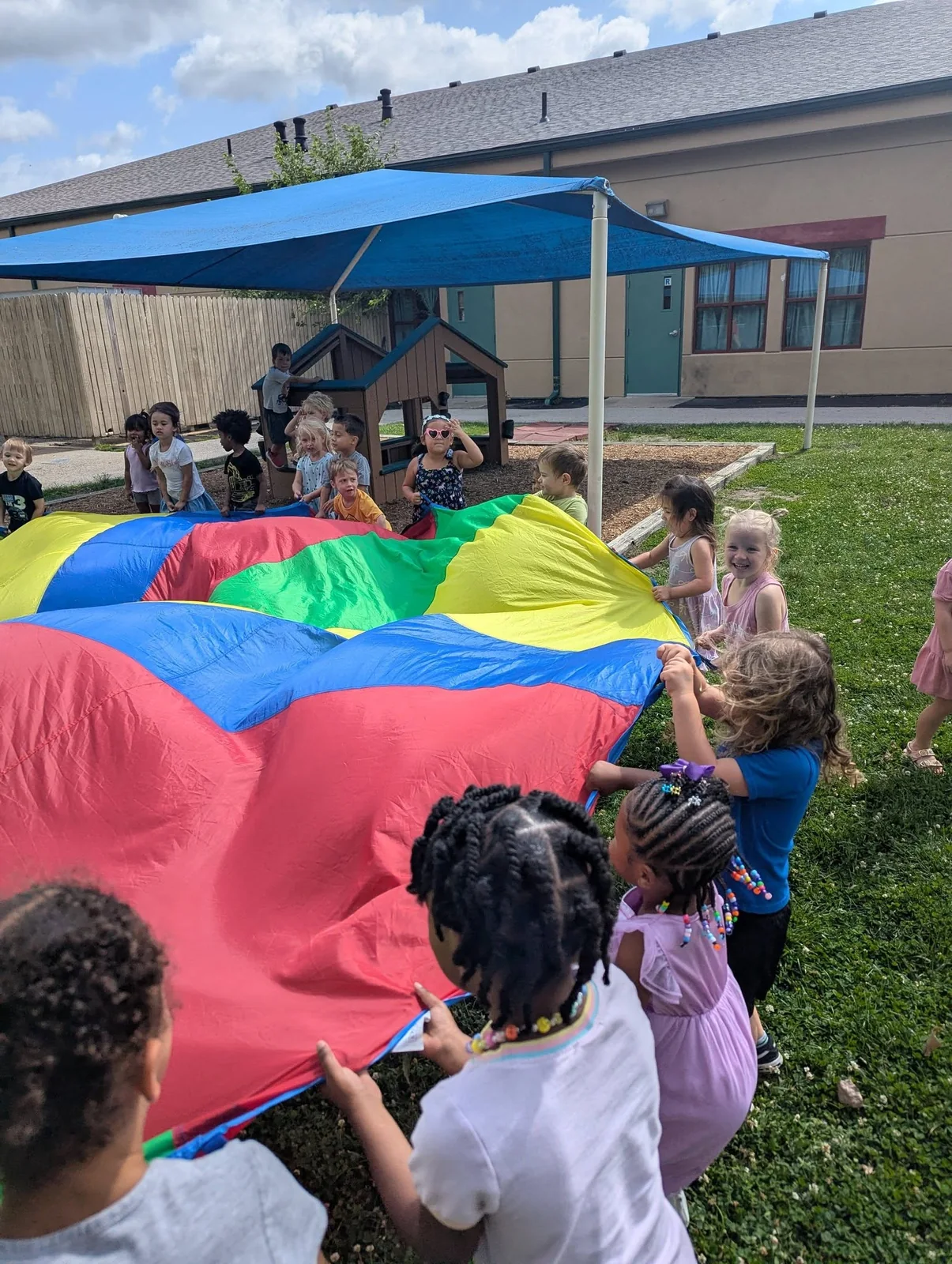 Children playing together with a colorful parachute on the Northland playground