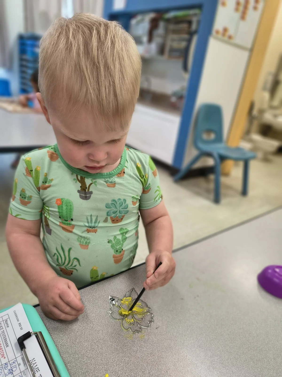 A child using a small tool to explore materials at a classroom table at Northland